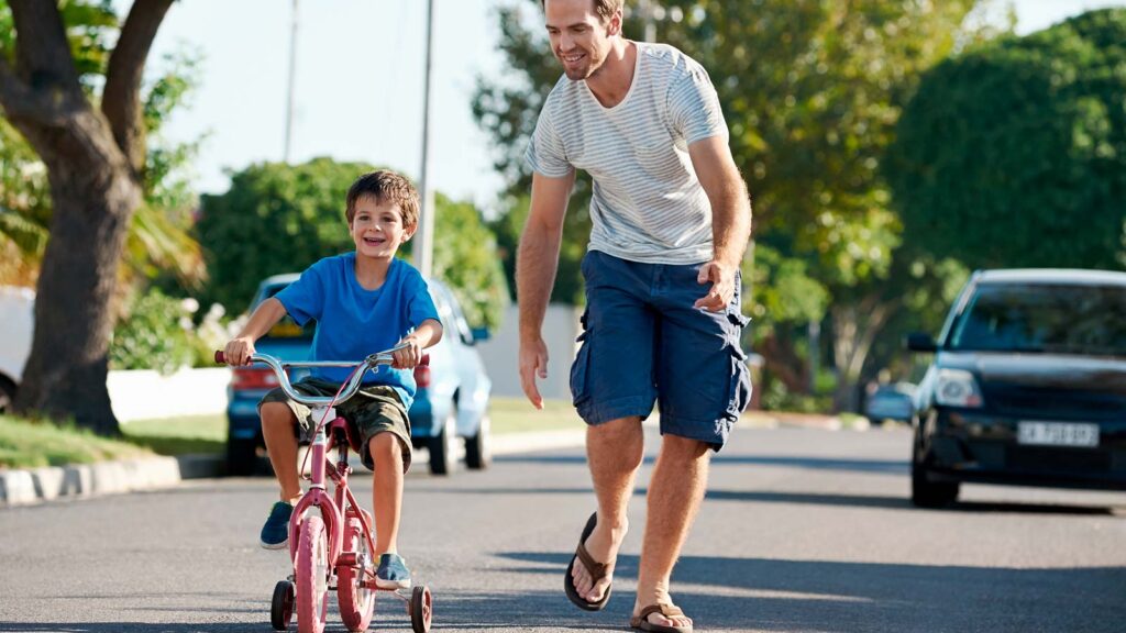 Billede af far der lærer sin dreng at cykle